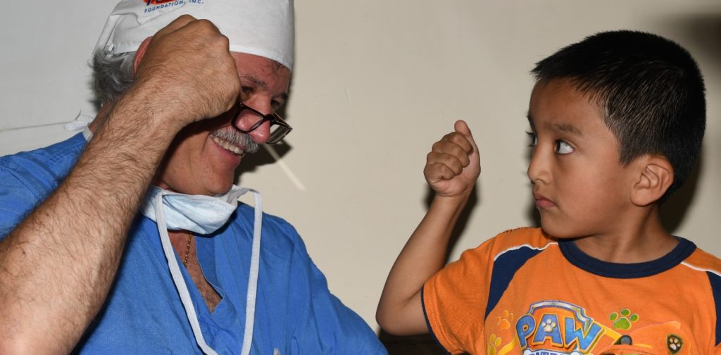 Dr. Quatela shares a fist bump during a HUGS Foundation medical mission trip.