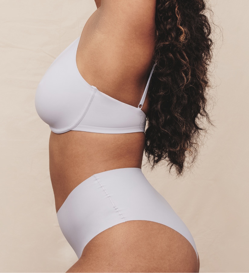 Woman wearing white bra and underwear arching back