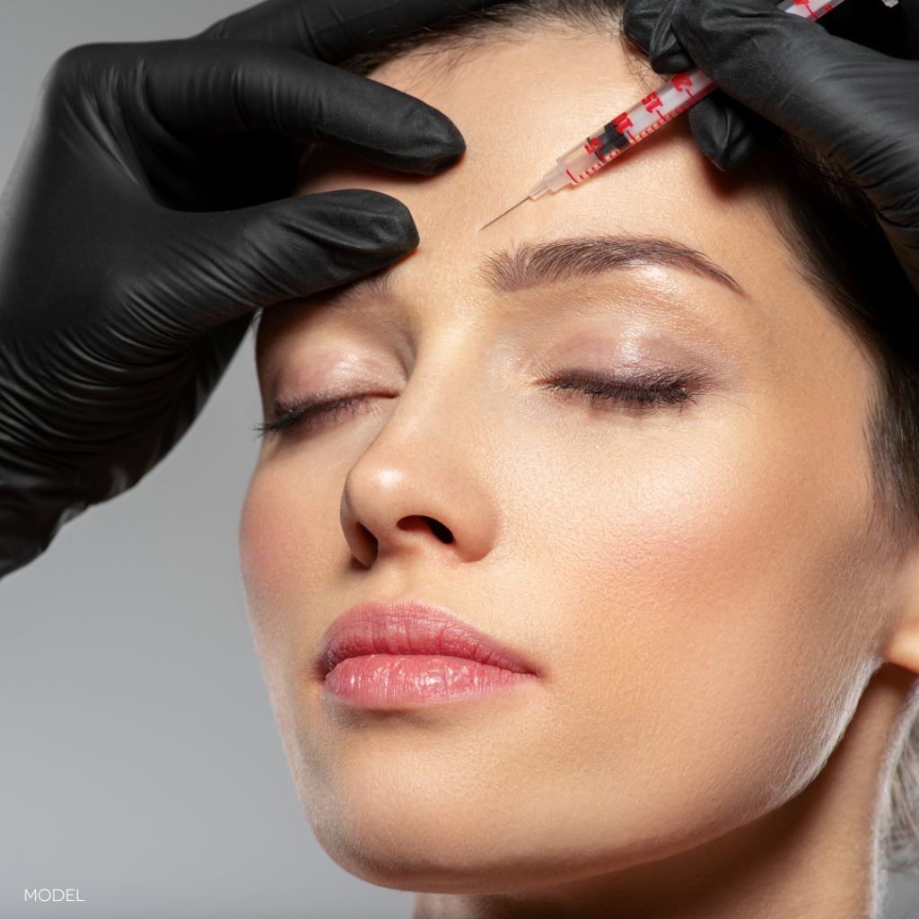 close up of woman's face with gloved hands and syringe